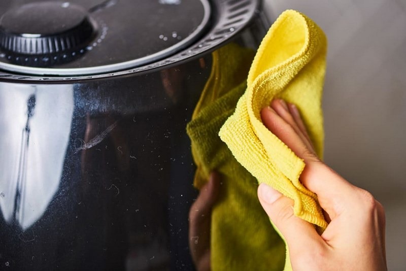 Dùng khăn lau để vệ sinh nồi chiên không dầu bên ngoài